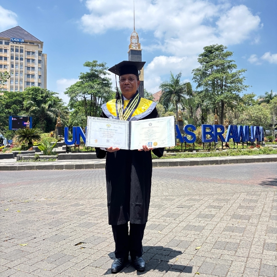 Momen bahagia Moh. Nalikan usai resmi diwisuda program doktor Universitas Brawijaya.