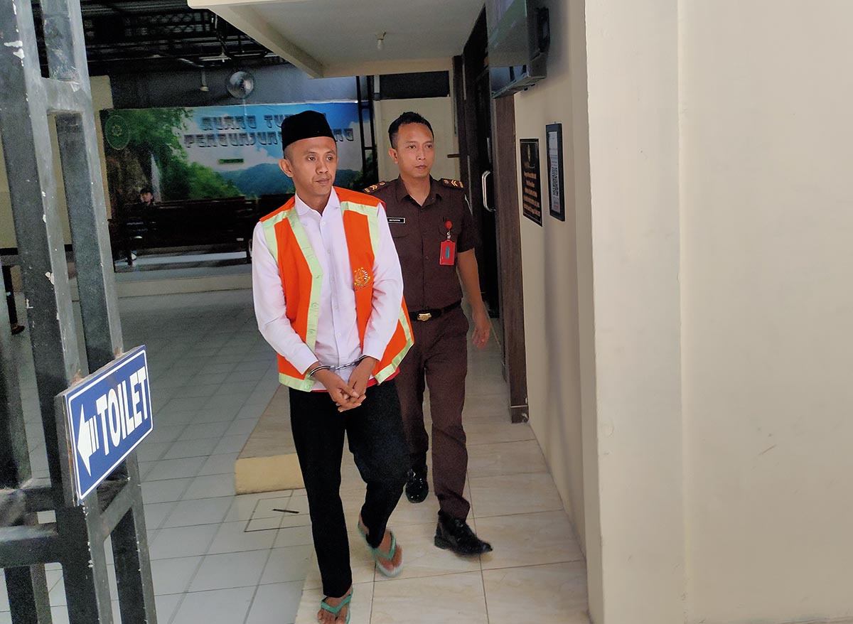 DITUNTUT 2,5 TAHUN: Sony dikawal petugas di Pengadilan Negeri Lamongan. Dia menjalani sidang kasus peredaran pil dobel L. (IST/RDR.LMG)