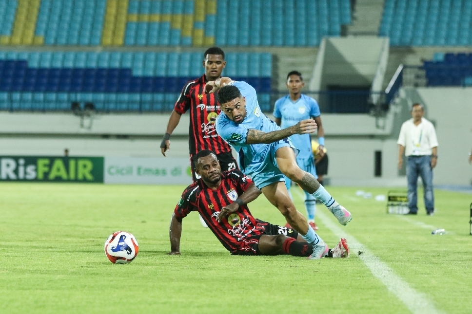 Jonathan Bustos berjibaku melewati hadangan pemain Persipura Jayapura.