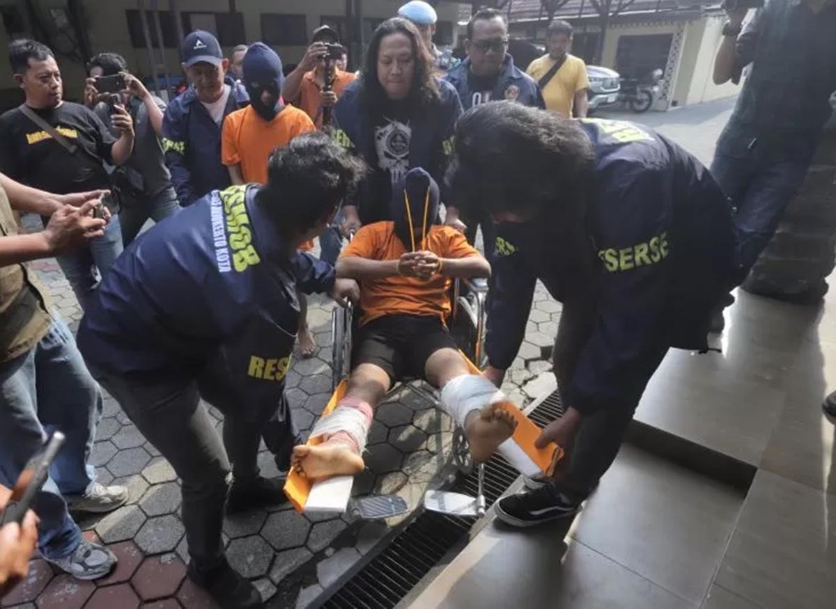 SETELAH DITEMBAK: Muhamad Hoirul Anam didorong menggunakan kursi roda menuju ruang tahanan Polres Mojokerto Kota. (sofan/jprm)