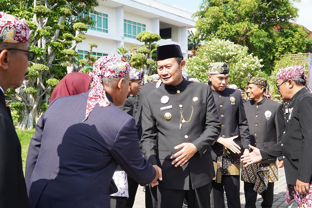 DUKUNG JATIM TUMBUH: Bupati Lamongan, Yuhronur Efendi, menyalami ASN pada upacara peringatan Hari Jadi ke-80 Provinsi Jatim di halaman Pemkab Lamongan. (HUMAS KOMINFO/RDR.LMG)