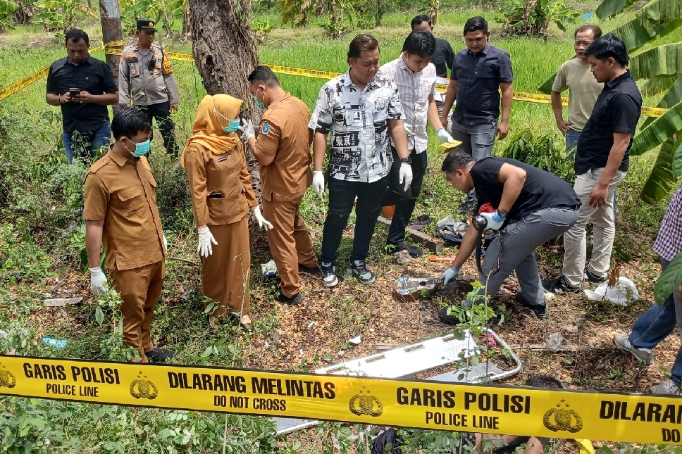 Petugas kepolisian bersama tim medis melakukan olah TKP penemuan mayat pria di pinggir Jalan Nasional Lamongan&ndash;Babat, Selasa (21/10).
