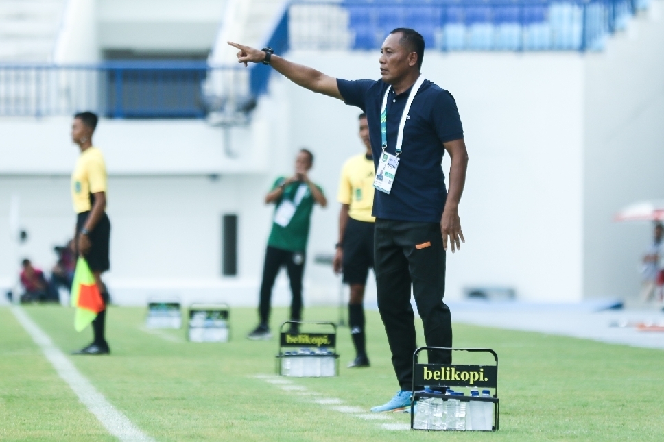 Pelatih sementara Persela Lamongan, Ragil Sudirman, memberikan arahan kepada pemain dari tepi lapangan saat laga berlangsung.