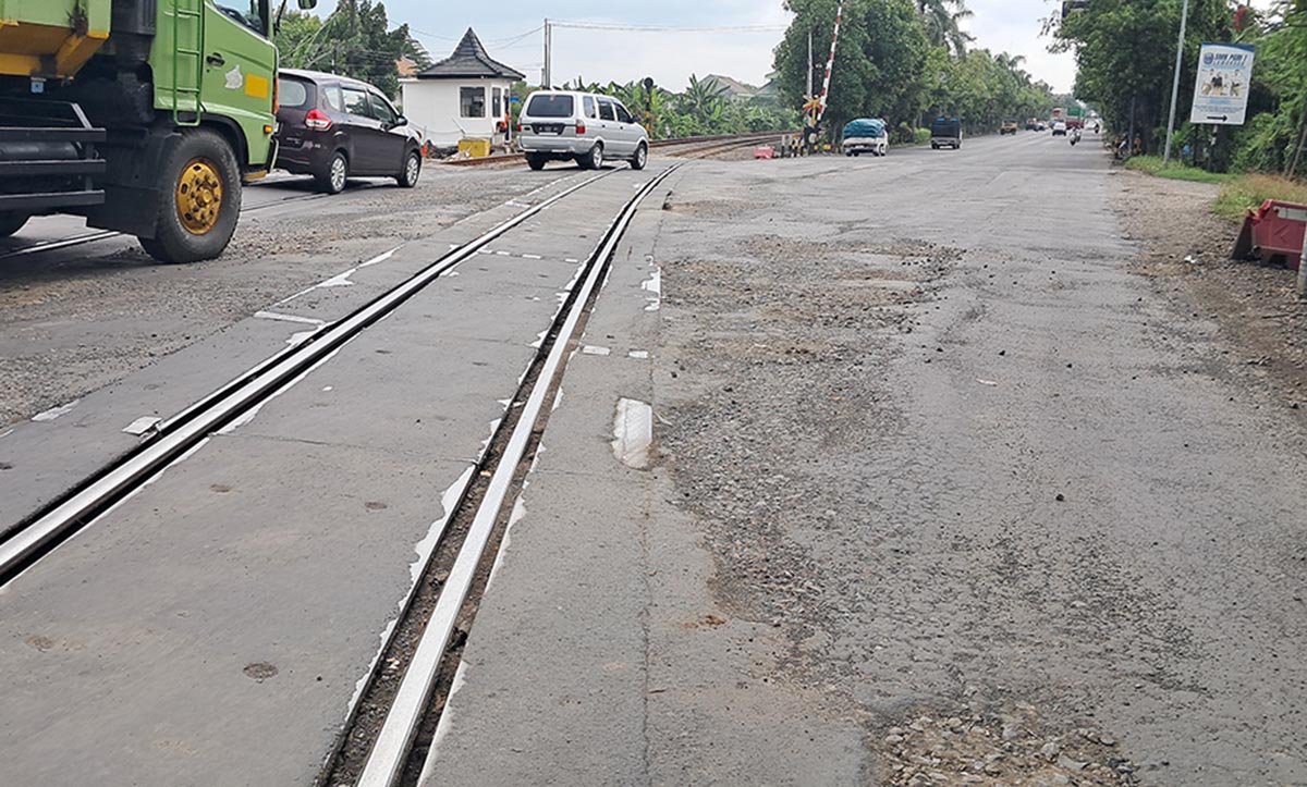 RUSAK: Kondisi jalan di sekitar perlintasan ganda kereta api di barat Terminal Lamongan. (GAMAL A/RDR.LMG)