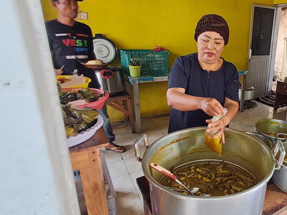 KETING BERTELUR PALING DICARI: Sakdiyah melayani pesanan pembelinya. Di warungnya, menu kelo kuning ikan keting bertelur paling dicari pelanggannya. (GAMAL A/RDR.LMG)