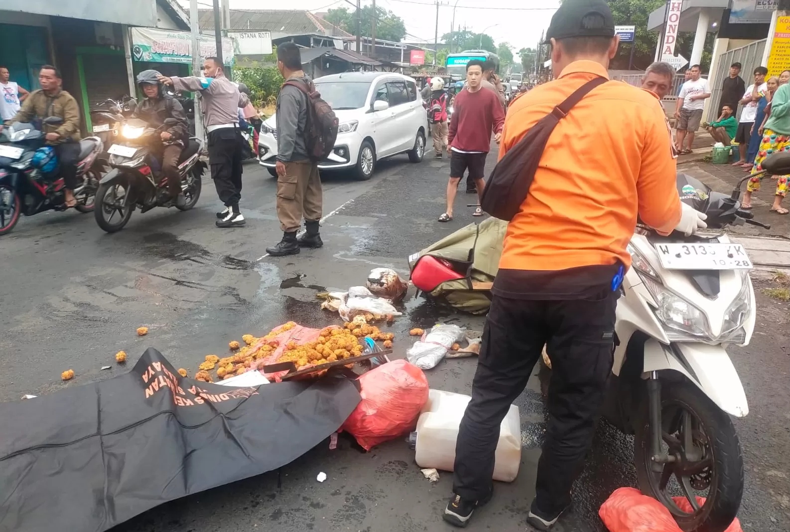 BERSERAKAN: Jenazah korban sebelum dievakuasi petugas. Penjual lontong balap asal Lamongan ini diduga menjadi korban tabrak lari di jalan Menganti, Surabaya. (Radar Surabaya)