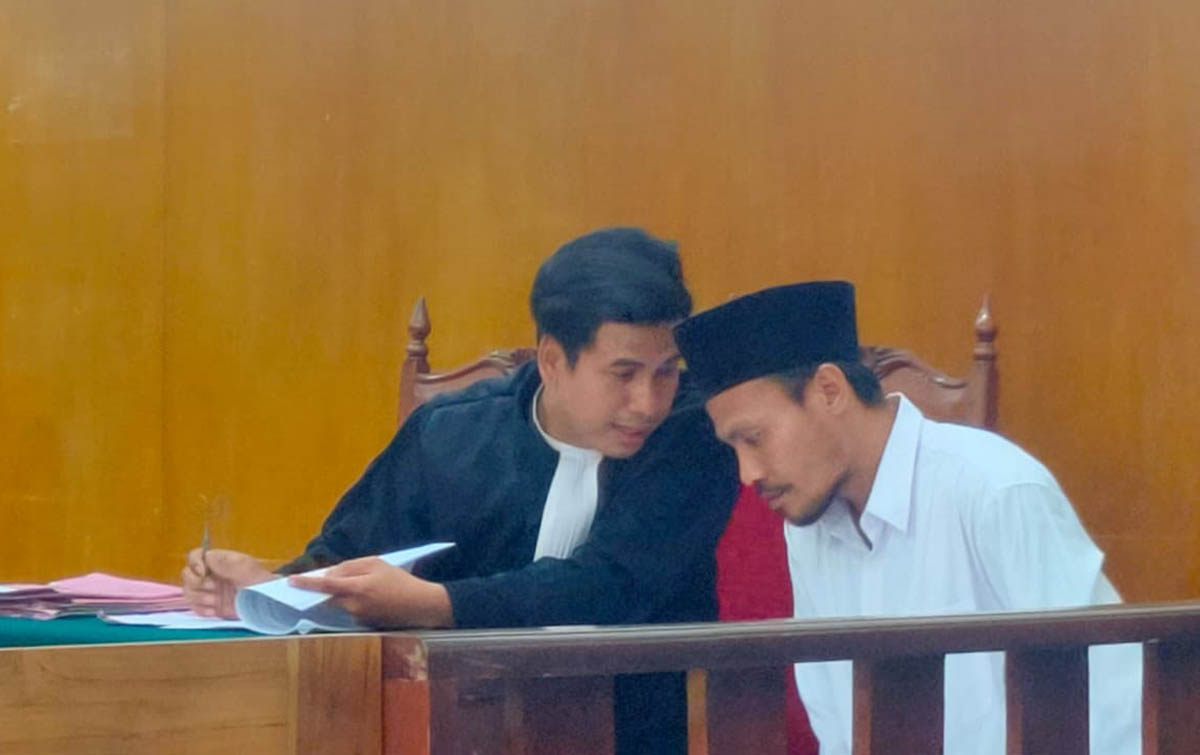 BAKAL AJUKAN PEMBELAAN: Eko Kuswoyo, terdakwa kasus penjualan ganja dan kepemilikan SS, berdiskusi dengan penasihat hukumnya. (IST/RDR.LMG)