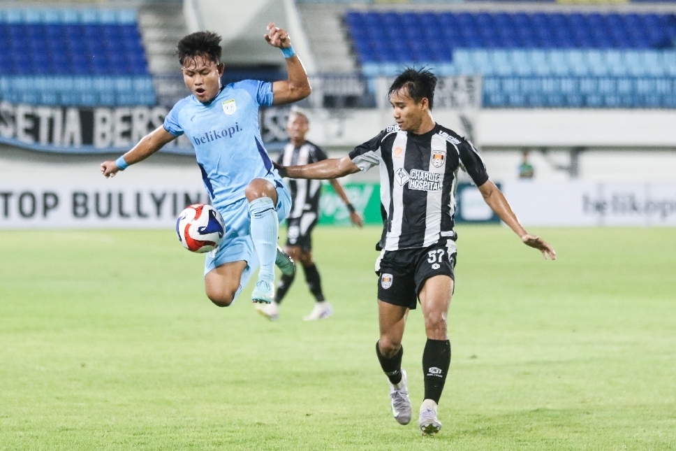 Pemain muda Persela, M. Sadewa (kiri), ditempel ketat pemain Kendal Tornado FC.