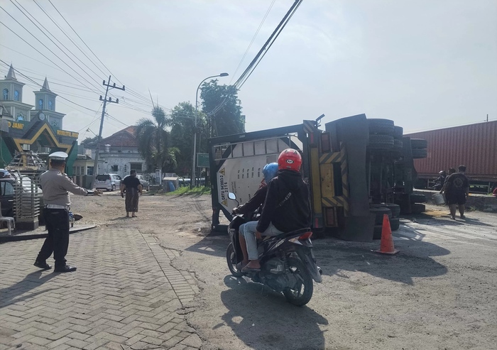 TERGULING : Sebuah truk tangki alaminkecelkaan tunggal hingga terguling di Jalan Raya Ambeng-Ambeng Watangrejo, Kecamatan Duduksampeyan, Gresik. (Riri/Radar Gresik)