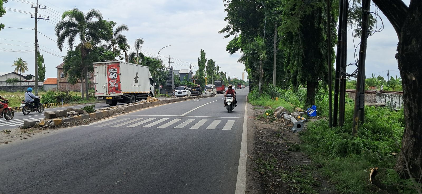 Tiang traffic lihgt masih tergeletak di sisi selatan jalan nasional, tepatnya di pintu masuk sisi barat JLU.&nbsp;