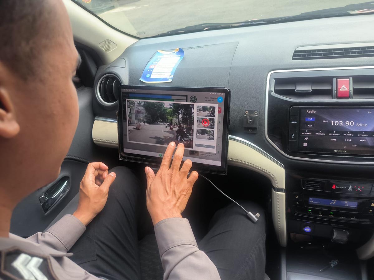 PANTAU DARI MOBIL PATROLI: Anggota Satlantas Polres Lamongan yang terlibat Operasi Zebra Semeru memantau menggunakan rekaman elektronik. (GAMAL A/RDR.LMG)