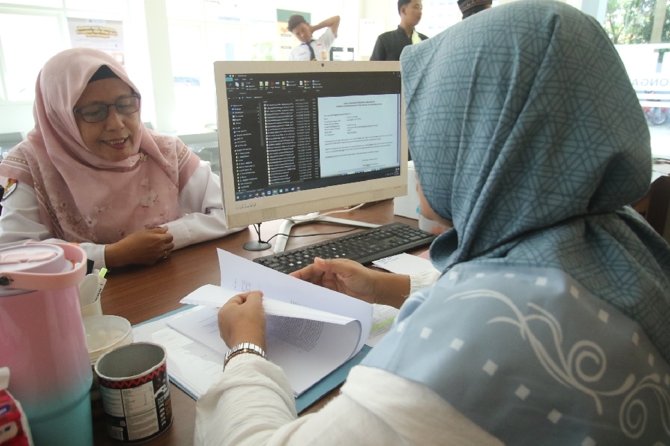 Pendaftar petugas penyelenggara ibadah haji (PPIH) berkonsultasi terkait persyaratan kepada petugas Kantor Kementerian Haji dan Umrah Kabupaten Lamongan.