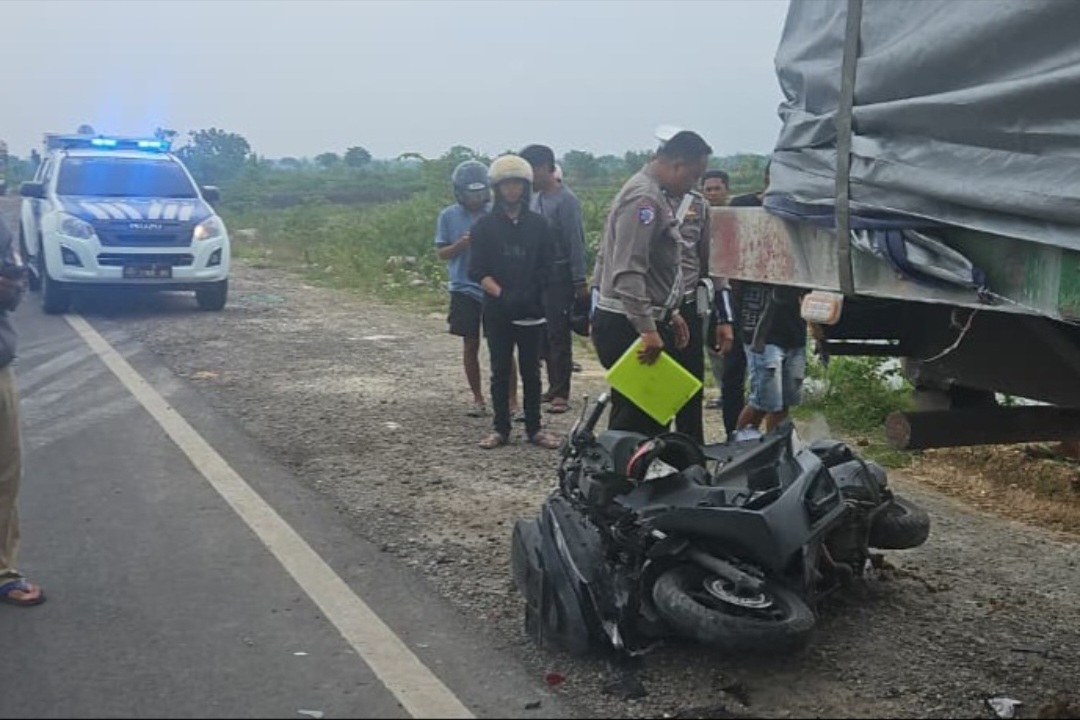 Kendaraan yang ditumpangi oleh korban tergeletak di pinggir jalan usai menabarak bagian belakang truk yang parkir di badan jalan.