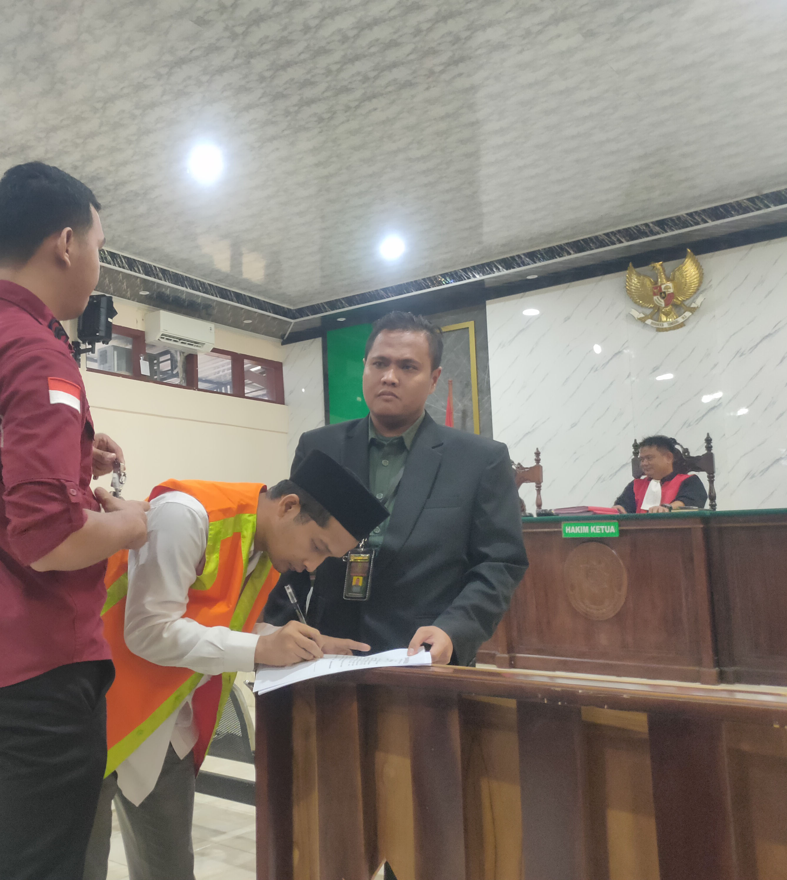 CURI HP &ndash; KAMERA TETANGGA: Terdakwa Muhammad Ghozali Abdillah menandatangani berkas setelah persidangan kasus pencurian di Pengadilan Negeri Lamongan. (ASIP ALAFI/RDR.LMG)