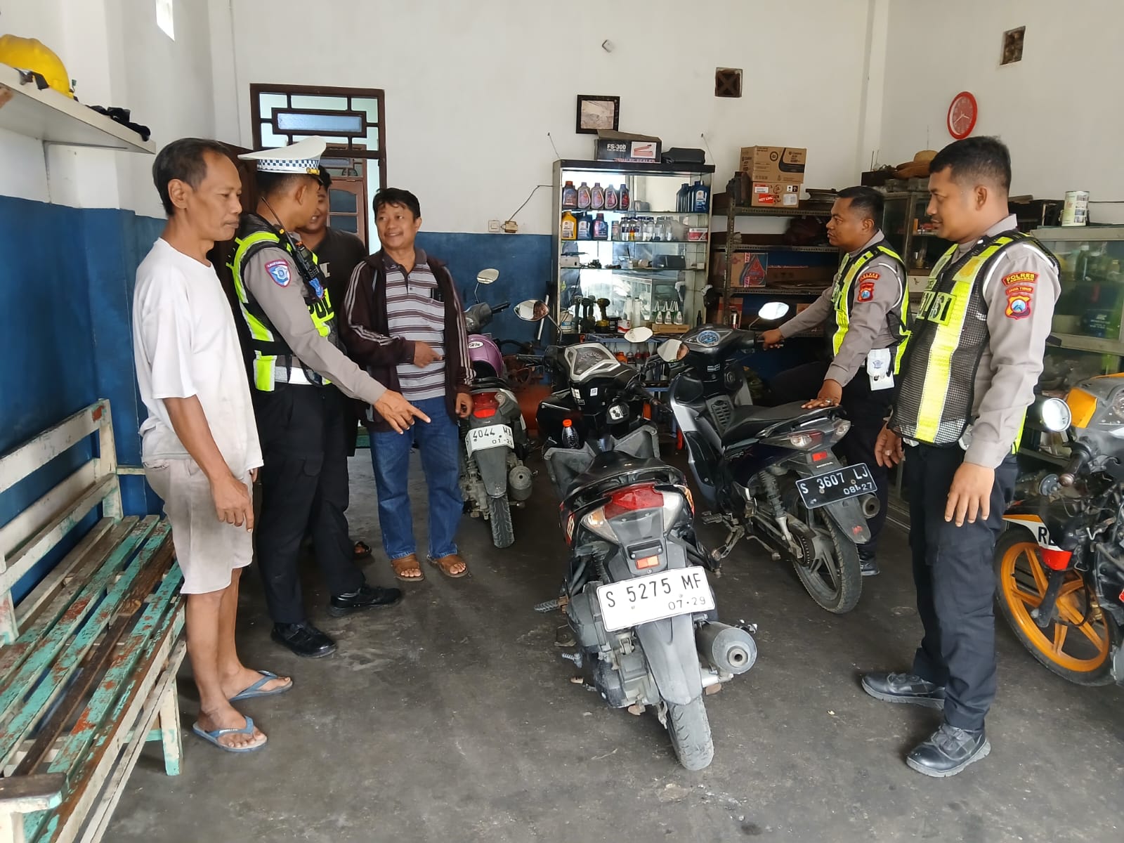 Petugas Satlantas Polres Lamongan saat memberikan edukasi kepada pemilik bengkel agar tidak menerima pemasangan knalpot brong jelang Nataru.