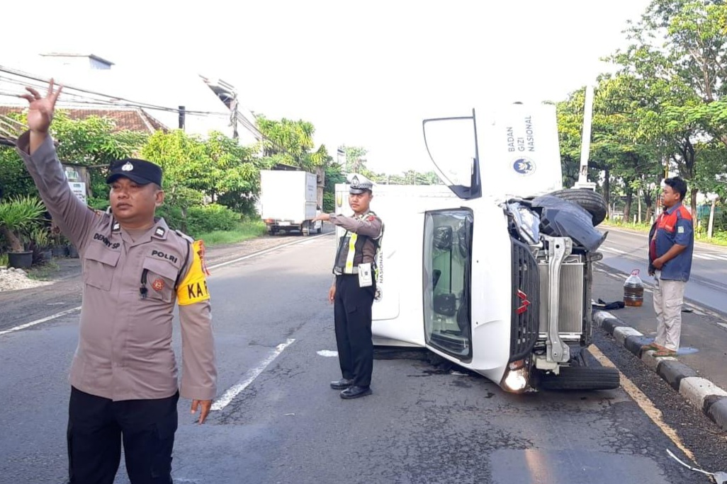 Mobil berstiker Badan Gizi Nasional (BGN) terguling di Jalan Poros Nasional Lamongan-Babat, Minggu (28/12) pagi.