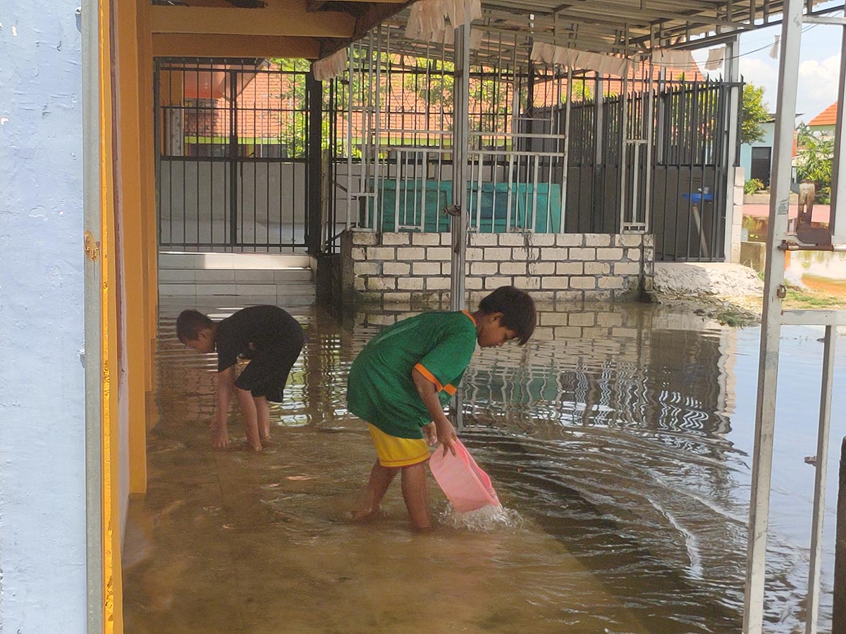 KEBANJIRAN: Anak &ndash; anak bermain di teras rumah yang kebanjiran. (IST/RDR.LMG)