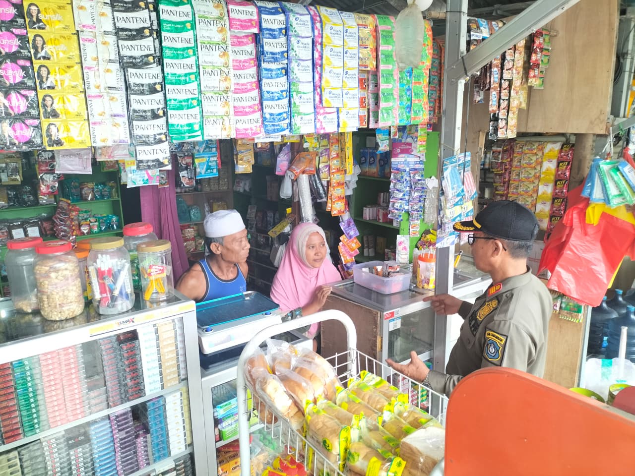 BERI PERINGATAN: Petugas Satpol PP Lamongan memberikan imbauan kepada pemilik toko kelontong agar tidak berjualan di trotoar.