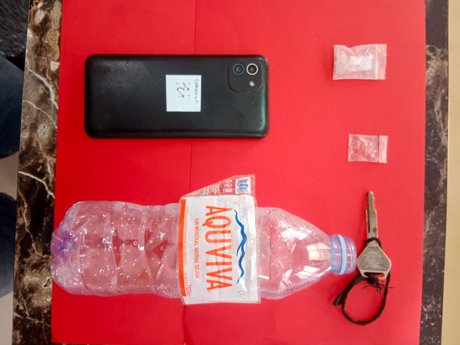 Barang bukti satu klip SS dengan berat 1,19 gram dan satu buah HP Samsung A03 warna hitam dari tangan M. Syahroni.