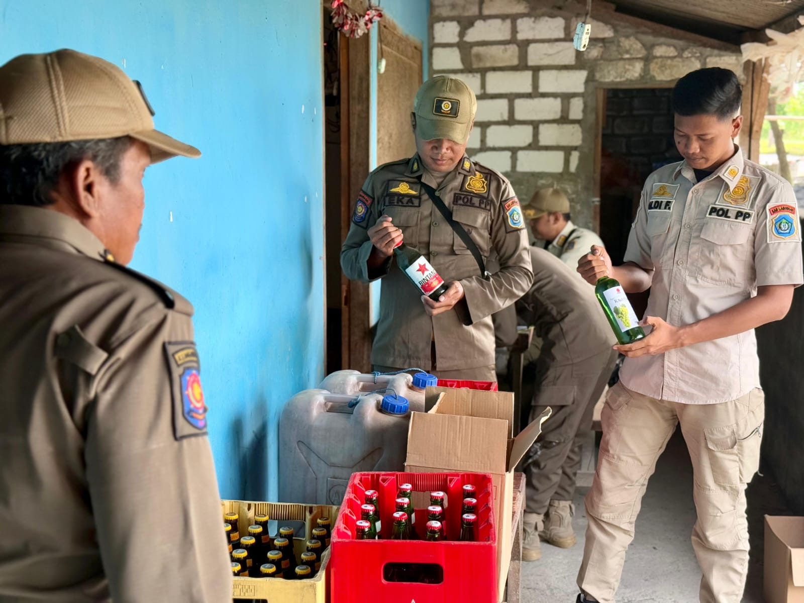 MERESAHKAN: Petugas mengangkut miras dari dua warung di Kecamatan Modo.
