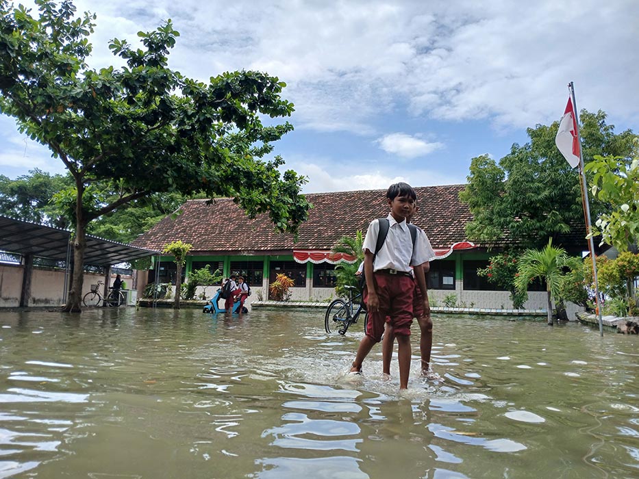 PULANG SEKOLAH: Siswa berjalan pulang di halaman sekolah yang mengalami kebanjiran di wilayah Bengawan Jero. (ANJAR DWI PRADIPTA/RDR.LMG)
