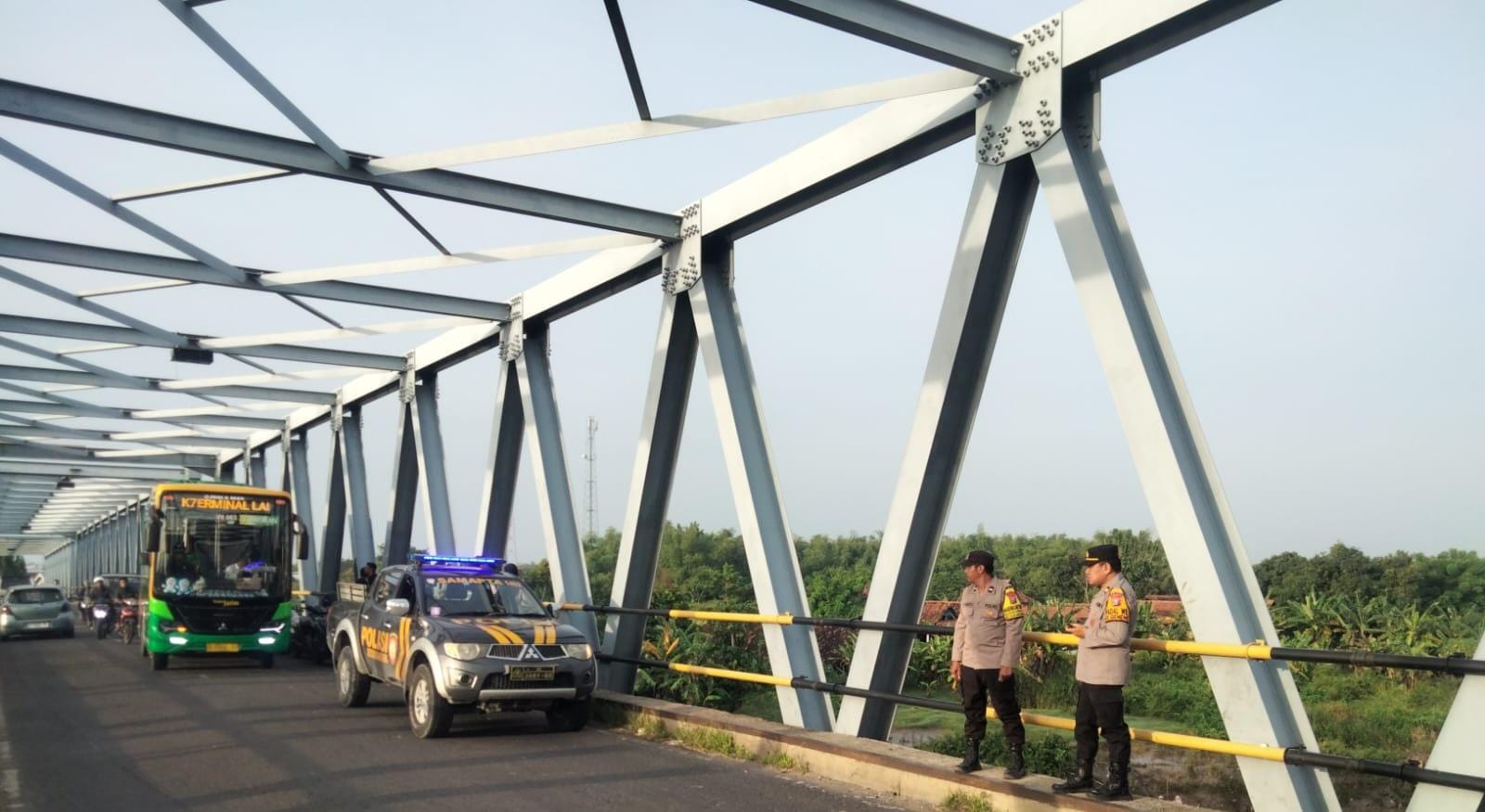 Petugas kepolisian saat menyisir lokasi jembatan untuk mencari pemilik motor yang terparkir di sana.