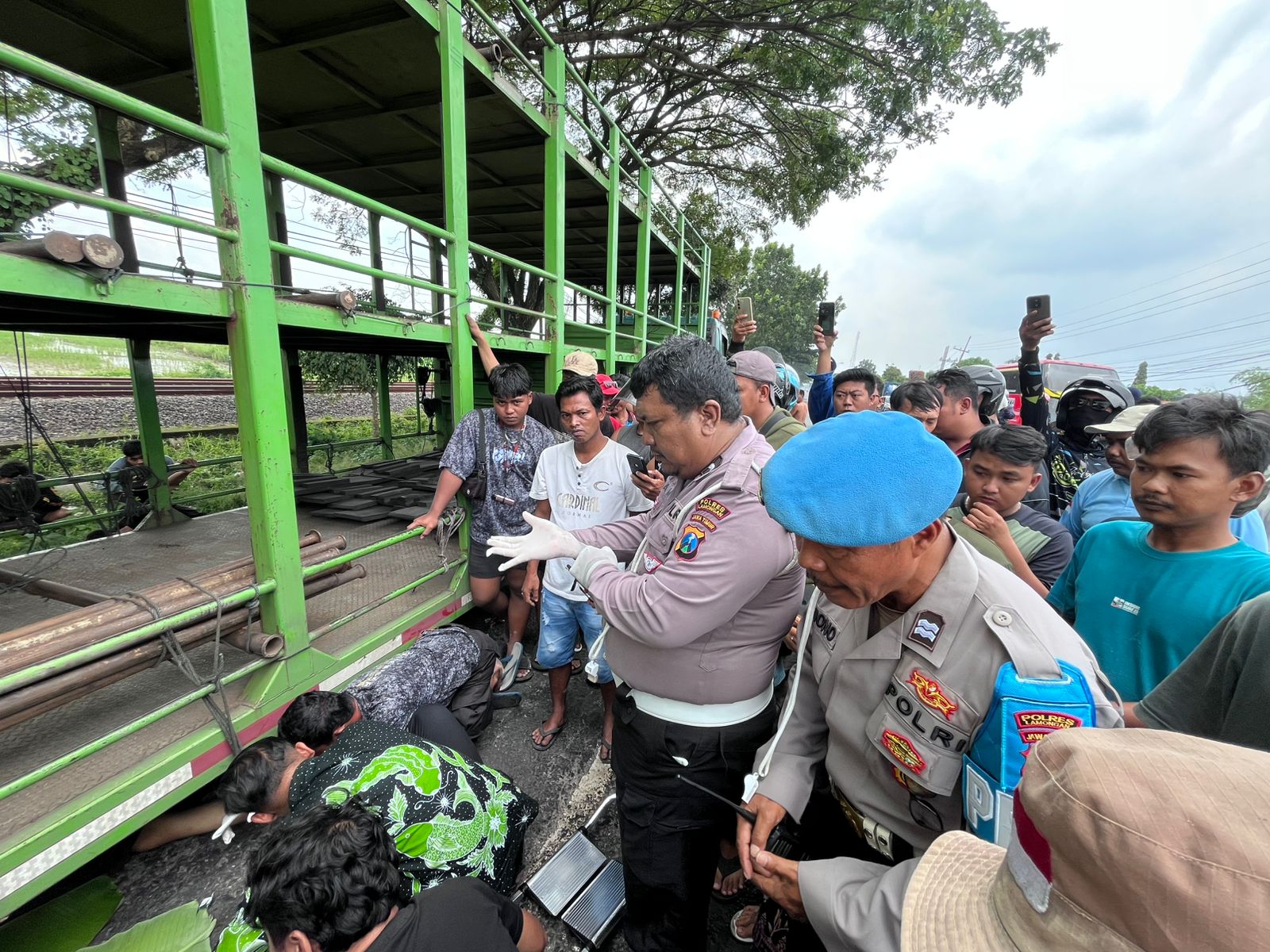 Petugas bersama warga mengevakuasi korban laka lantas di jalan nasional Lamongan-Babat yang melibatkan truk dengan sepeda motor.