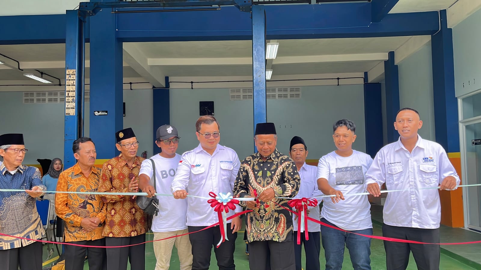 SIMBOLIS: Ketua PDM Lamongan Drs. KH. Shodikin, M.Pd menggunting pita disaksikan Kepala Sekolah SMK Muhammadiyah 1 Lamongan Afnan Nurdin, SE.M.M. dan Direktur Utama Group Recky Davinci Djaya Putra, ST