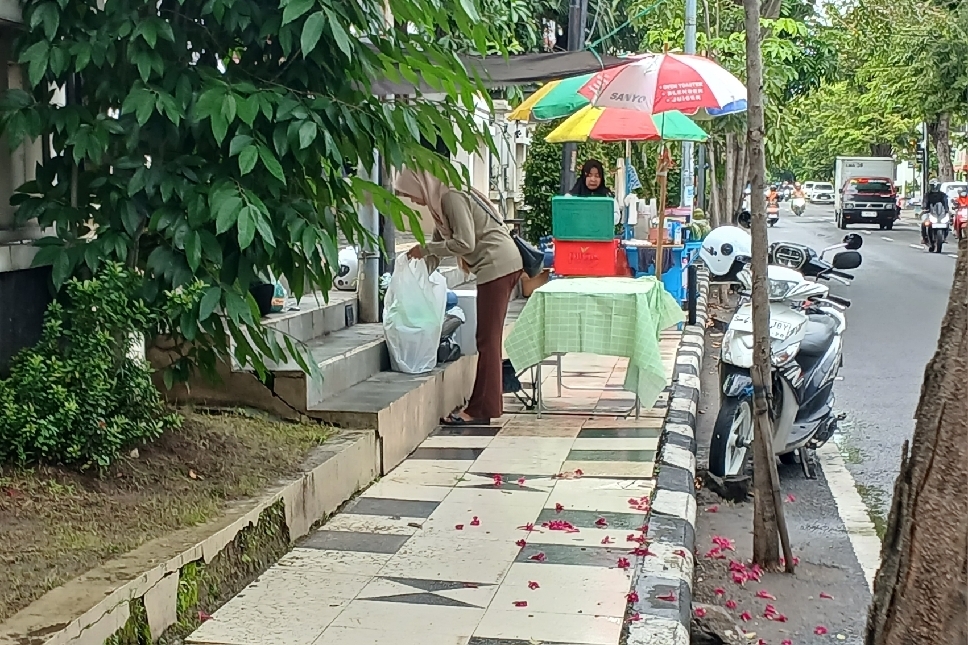 MANFAATKAN MOMEN: Salah satu pedagang dadakan menjajakan menu takjil di atas trotoar di pinggir Jalan Basuki Rahmad.