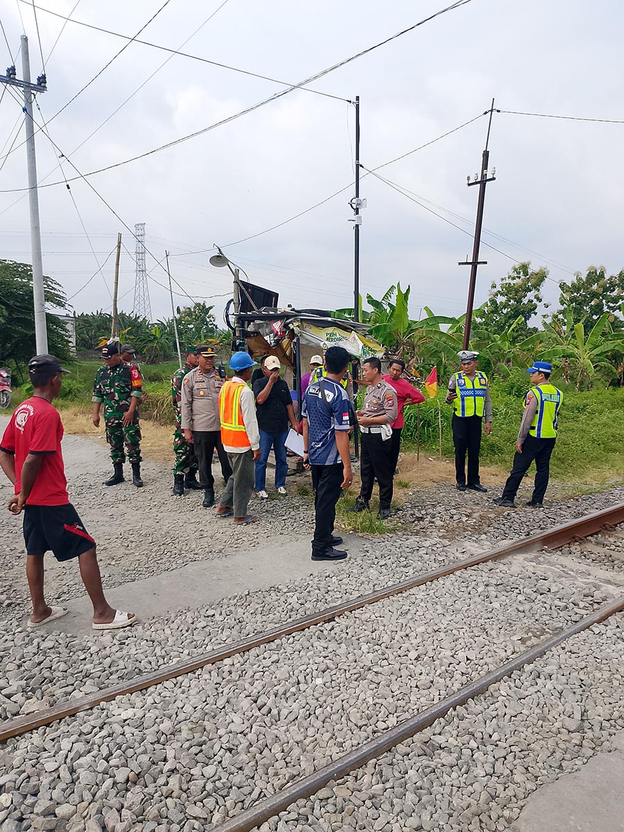 DATANGI LOKASI KEJADIAN: Petugas kepolisian meminta keterangan warga di perlintasan tanpa palang pintu Desa Sumurgenuk, Kecamatan Babat. (IST/RDR.LMG)