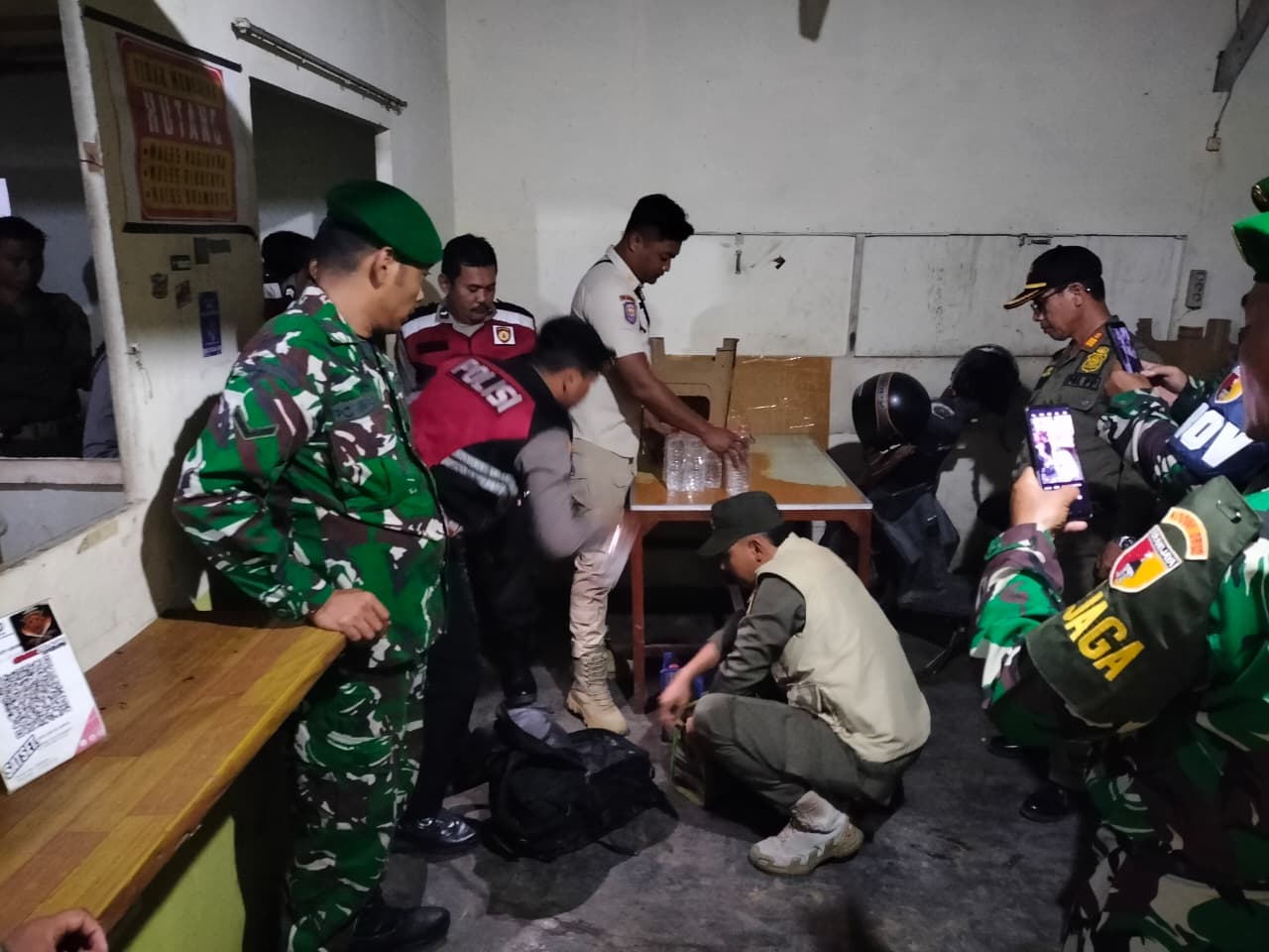 MELANGGAR: Petugas gabungan saat mengamankan miras dari salah satu warung di pusat Lamongan.