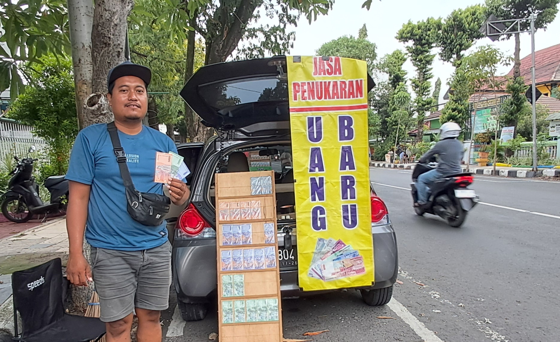 Salah satu penyedia jasa penukaran uang baru membuka lapak di pinggir jalan protokol. 