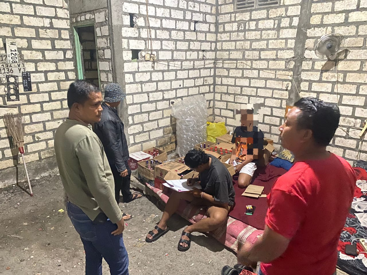 petugas mengamankan beberapa botol minuman keras yang disimpan di sebuah rumah milih warga di Kecamatan Karangbinangun, Jumat (6/3).
