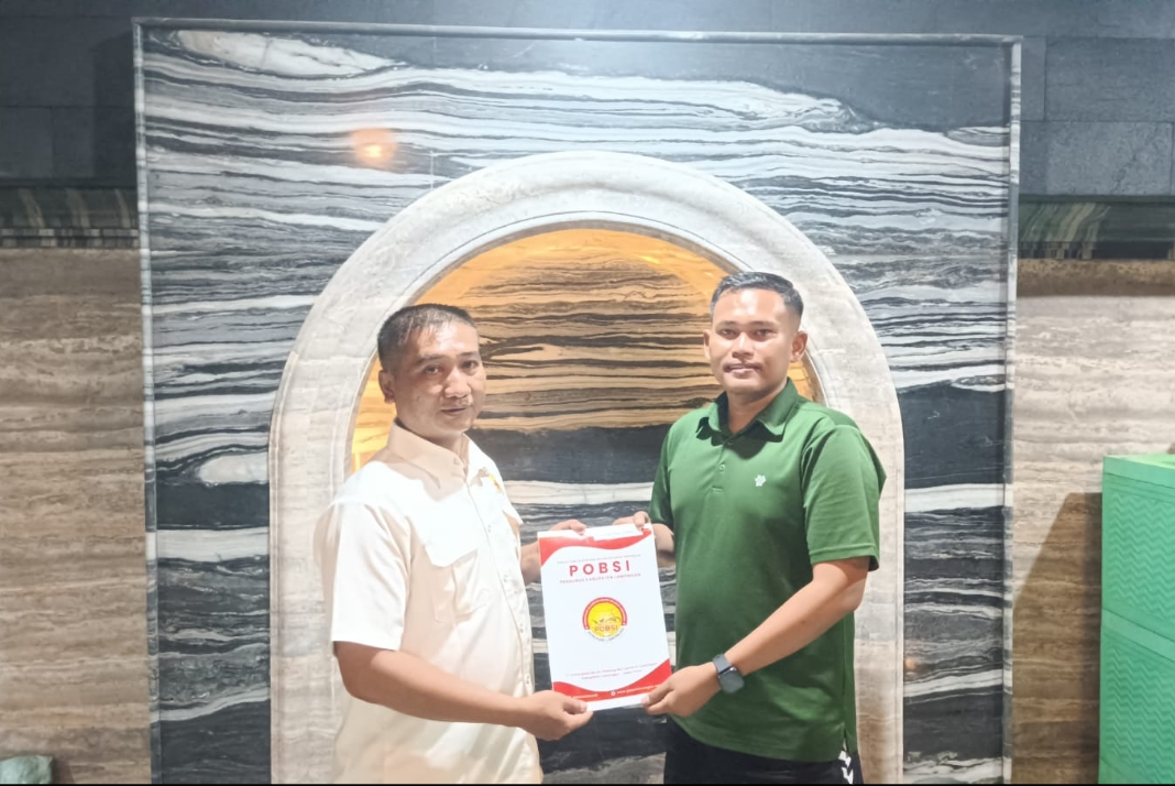 Dimas Setiawan (berkaus hijau) saat menerima SK Venue Kejurprov X Biliar Jatim dari Ketua Harian POBSI Lamongan Arman. 