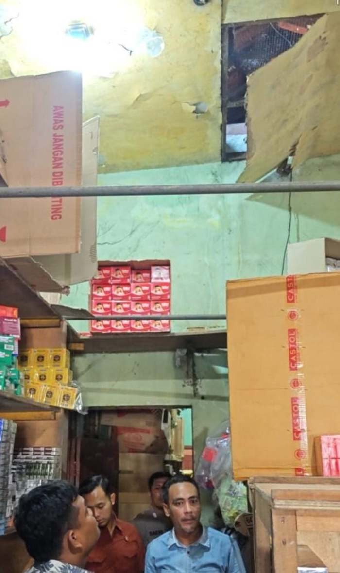 CARI PETUNJUK: Petugas mencari sidik jari pelaku di toko yang dibobol