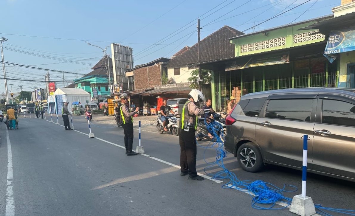 Petugas memasang pembatas di Jalan Raya Babat. 