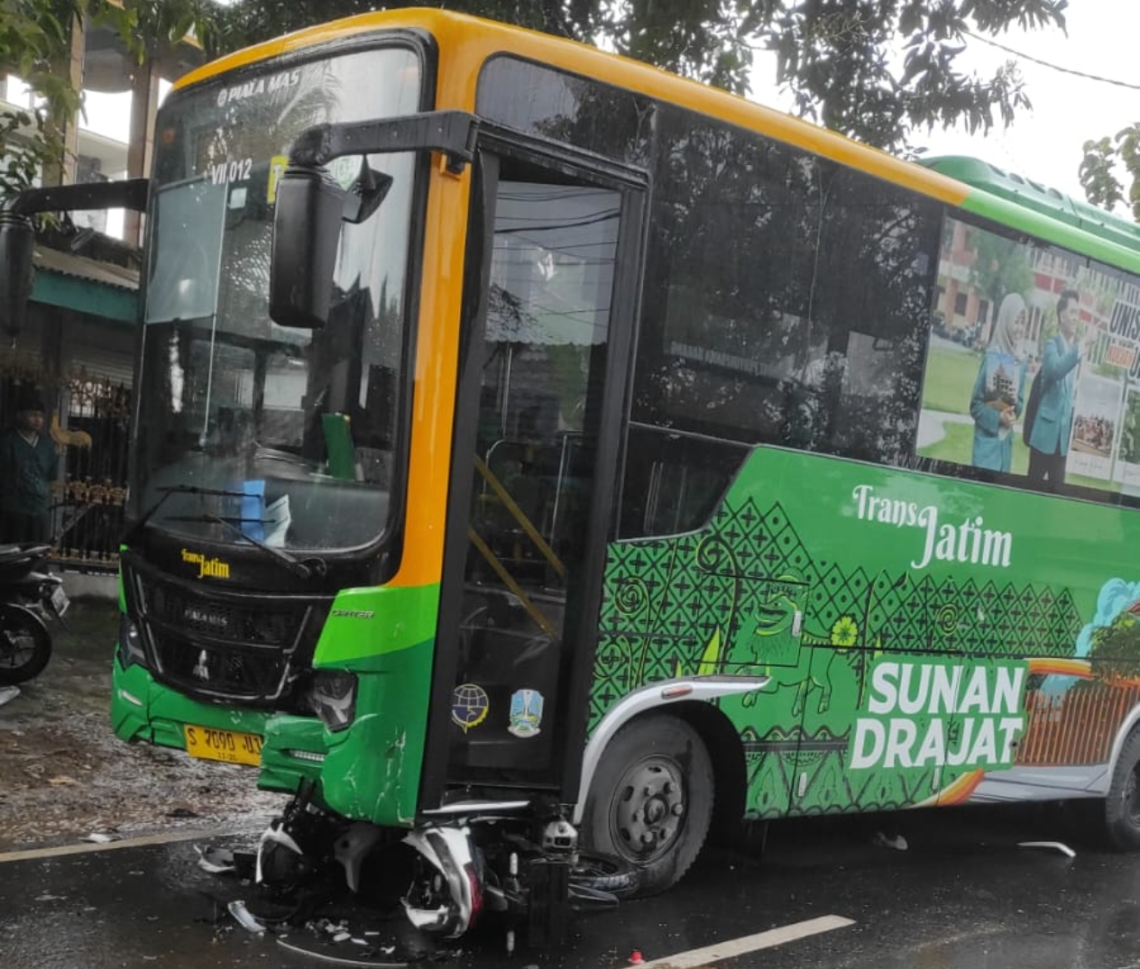 Motor matik berada di bawah kolong depan Bus Trans Jatim usai terlibat kecelakaan.  