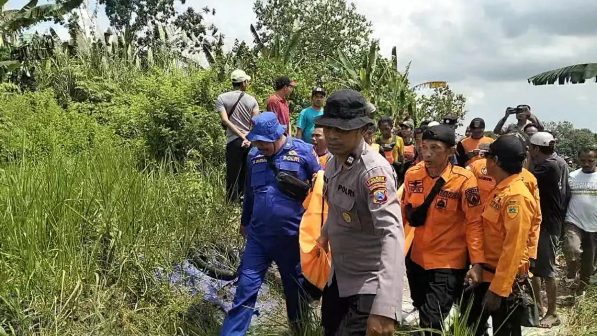 Petugas gabungan mengevakuasi jenazah AF, 9, yang tenggelam di aliran Sungai Bengawan Solo. (ISTIMEWA/RADAR LAMONGAN)