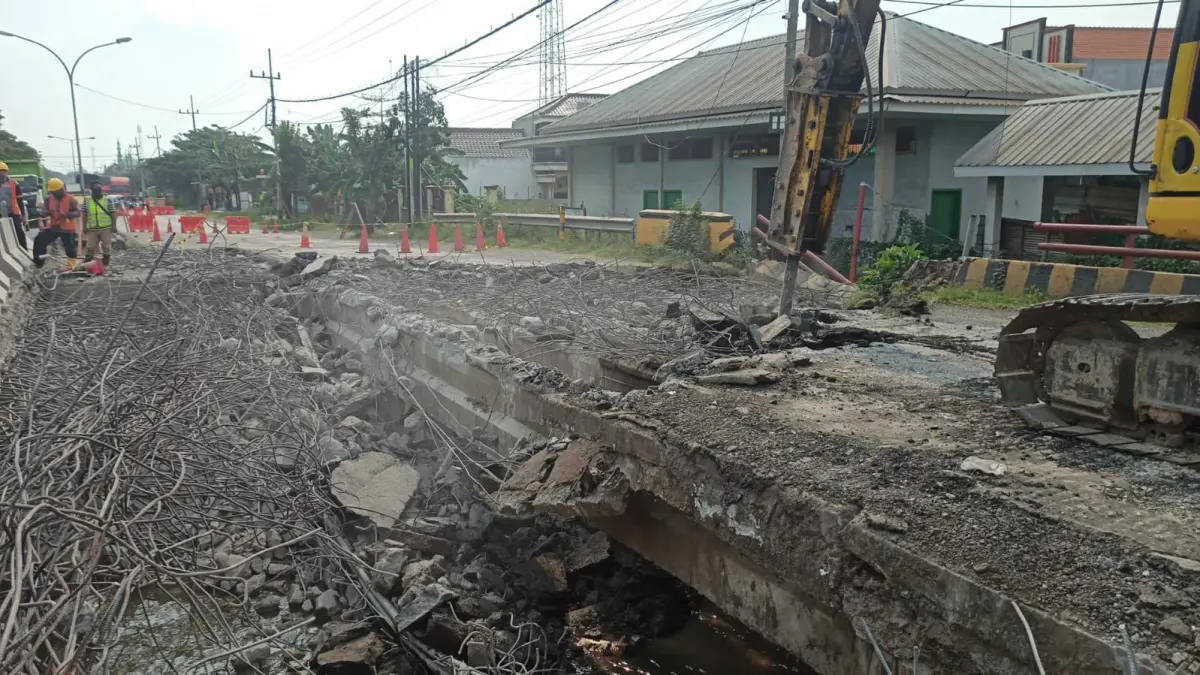Alat berat dijalankan untuk membongkar struktur bangunan jembatan lama di Desa Kesambi, Kecamatan Pucuk. (GAMAL AYATULLAH/RADAR LAMONGAN)