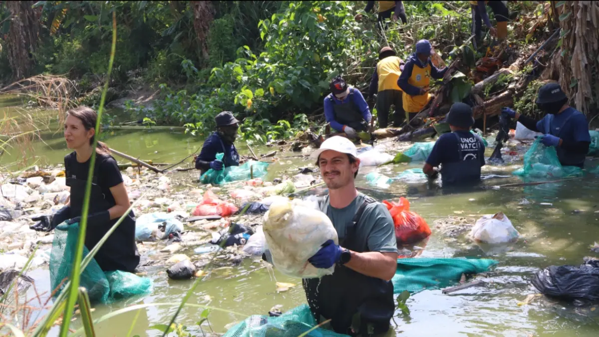 Aktivis lingkungan dari Sungai Watch saat membersihkan sampah di Sungai Mengkuli. (ASIP ALAFI/RADAR LAMONGAN)