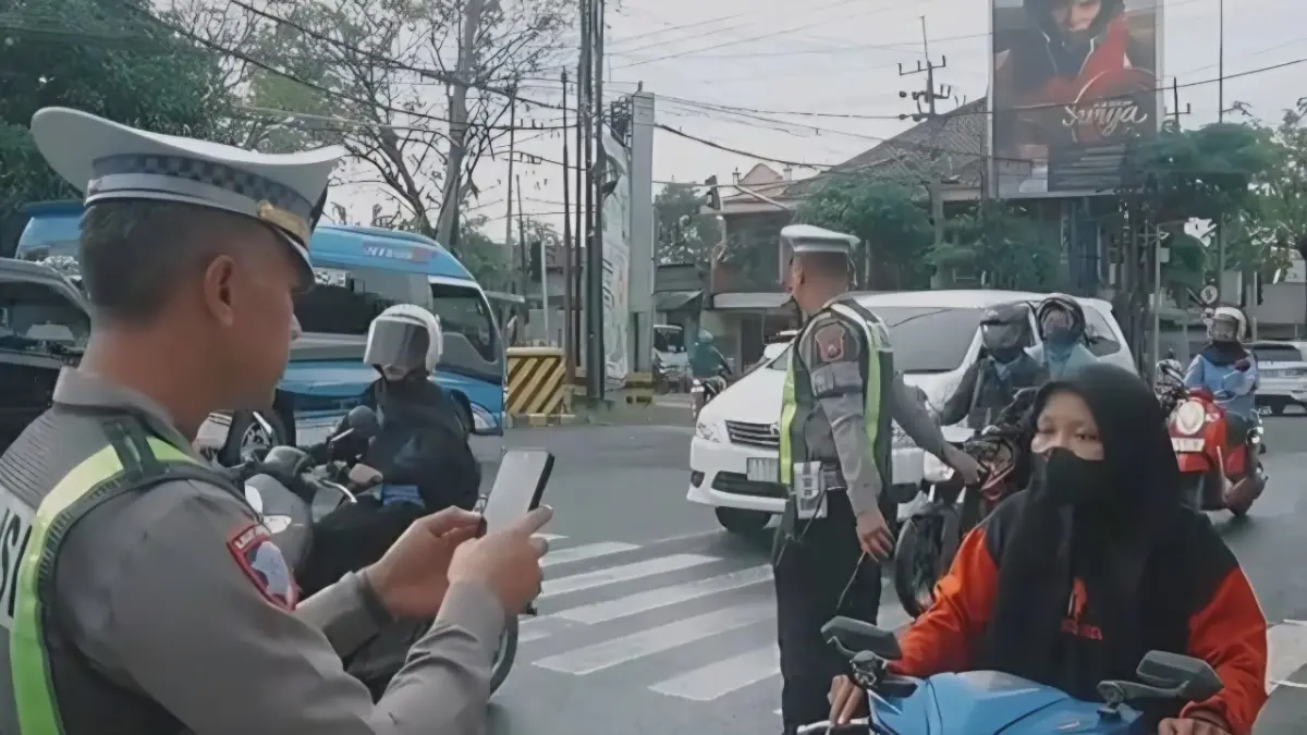 BISA REKAM DIMANA SAJA: Petugas memotret pengendara motor yang melanggar aturan berlalu lintas.&nbsp;(Gamal A/Radar Lamongan) 