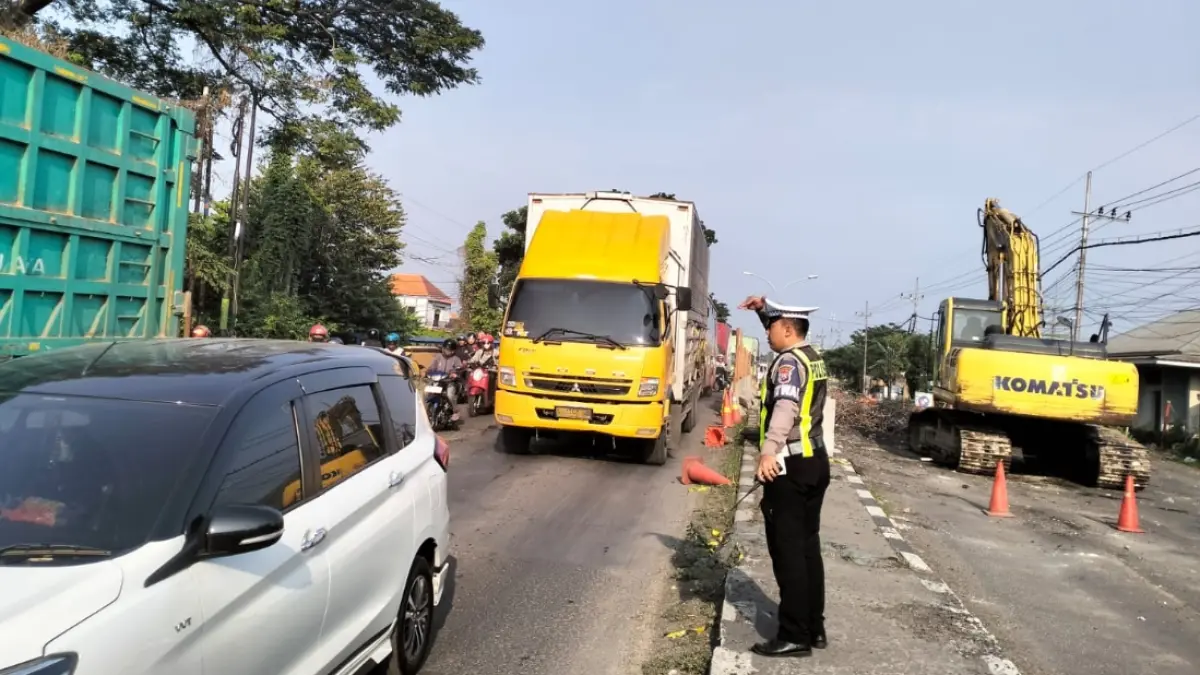 Petugas kepolisian mengatur arus lalu lintas di titik jembatan jalan nasional yang diperbaiki. (ISTIMEWA/RADAR LAMONGAN)