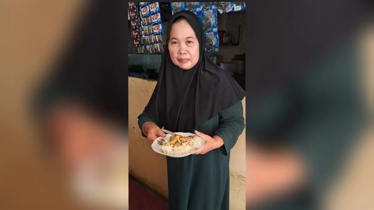 RESEP DARI WARISAN ORANG TUA: Sri Andayani membawa sepiring nasi kare ayam buatannya di warungnya.&nbsp;(Gamal A/Radar Lamongan) 