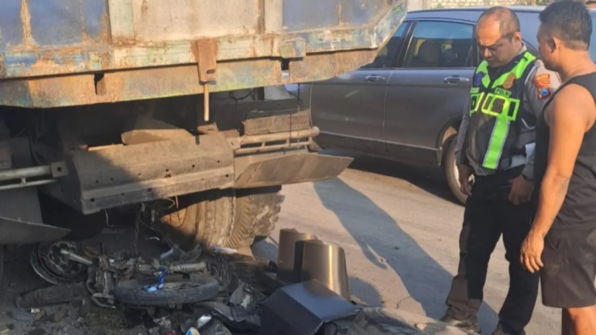 Petugas kepolisian mengecek kondisi motor usai tertabrak dump truk di traffic light jalan nasional di Desa Pucuk. (ISTIMEWA/RADAR LAMONGAN)