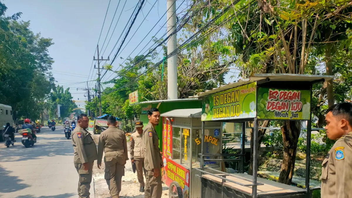 DITERTIBKAN: Gerobak PKL di Jalan Sumargo Lamongan ditertibkan petugas Satpol PP. (Gamal A/Radar Lamongan) 