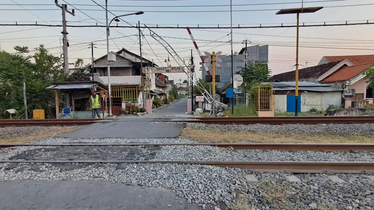 RUSAK : Perlintasan di Deket Kulon dijaga karena palang pintunya mengalami kerusakan mesin. (Gamal A/Radar Lamongan) 