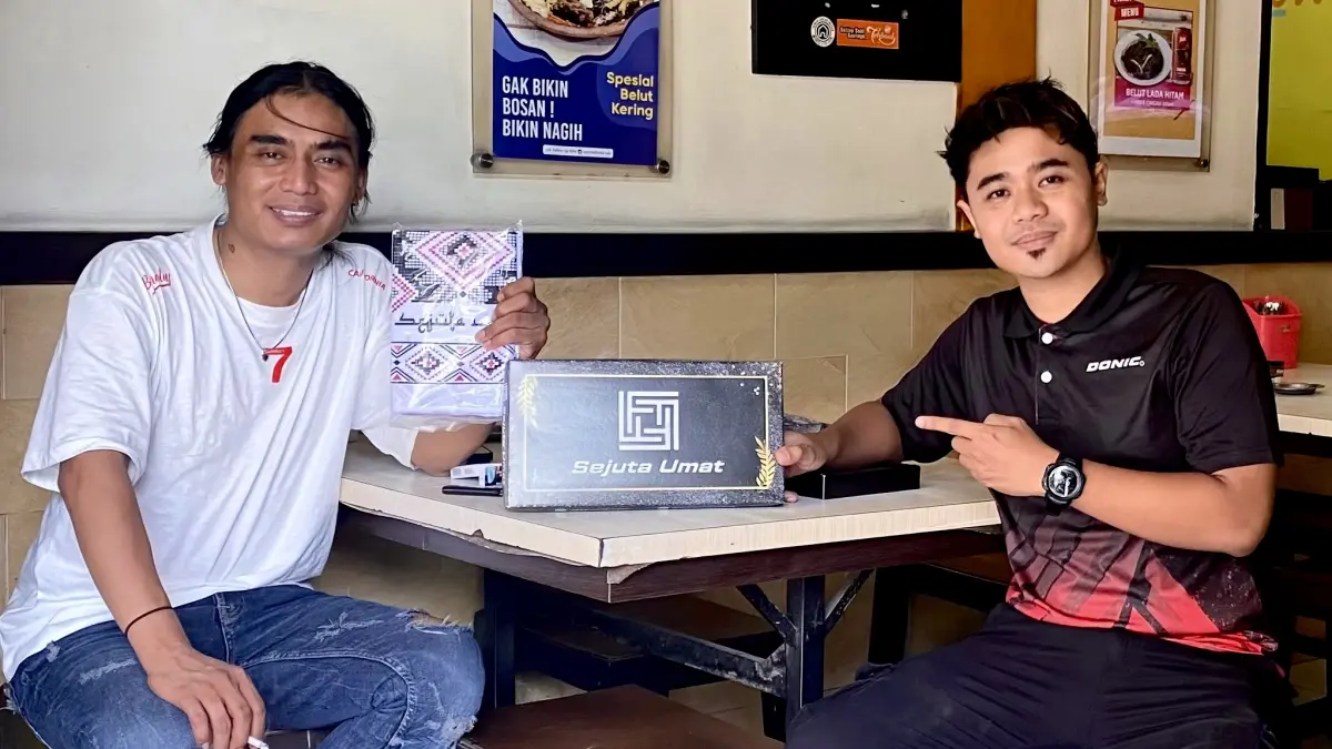Penyerahan sarung SEJUTA UMAT kepada Charly Van Houtten. (IG @SEJUTAUMAT.LMG/RDR.LMG) 
