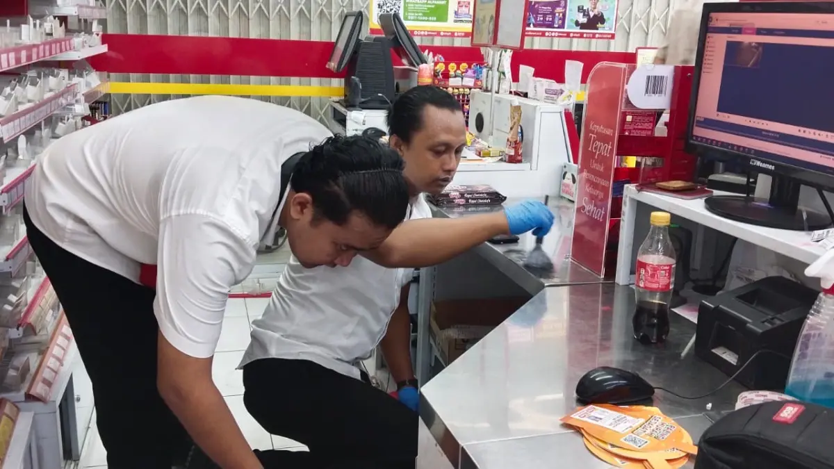 Petugas kepolisian melakukan olah TKP pada minimarket yang dibobol pencuri. (GAMAL AYATULLAH/RADAR LAMONGAN)