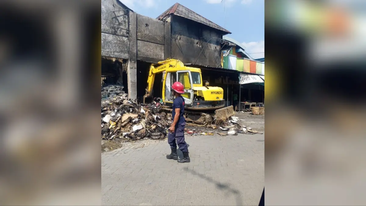 DATANGKAN ALAT BERAT: Tumpukan barang sisa kebakaran dikeluarkan dengan menggunakan alat berat sekaligus memastikan tidak ada lagi titik api yang muncul. (Istimewa/Radar Lamongan) 