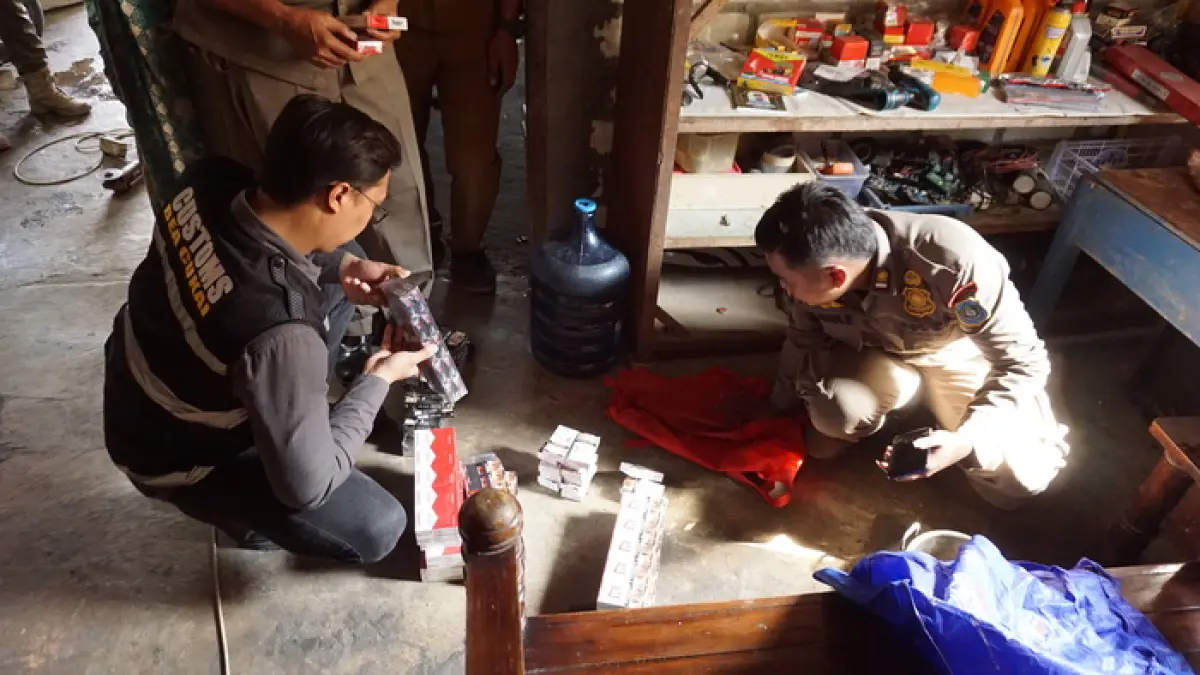 TURUN KE LAPANGAN: Petugas mendatangi penjual rokok untuk memastikan tidak ada peredaran rokok ilegal.&nbsp;(Humas Kominfo/Radar Lamongan) 